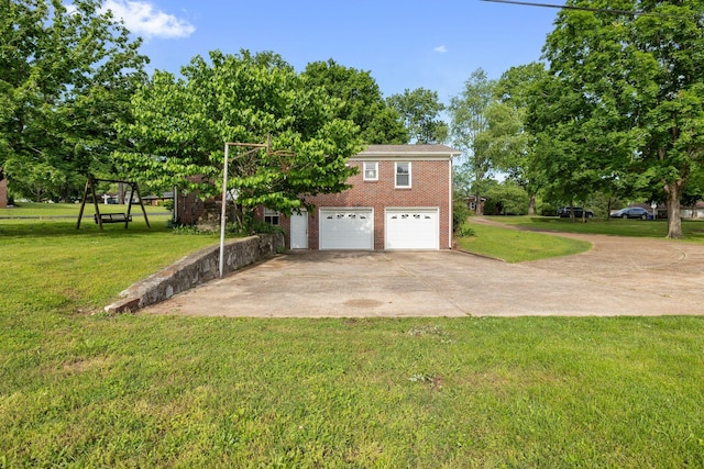 view of front of property with concrete driveway, brick siding, an attached garage, a front yard, and view of wooded area