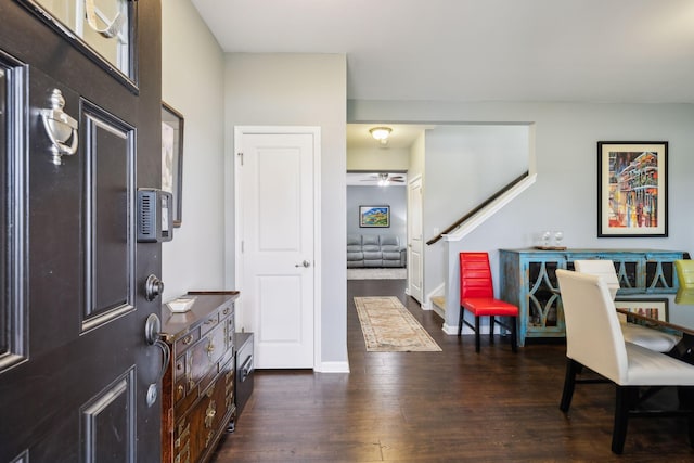 entrance foyer featuring dark wood finished floors, stairs, ceiling fan, and baseboards