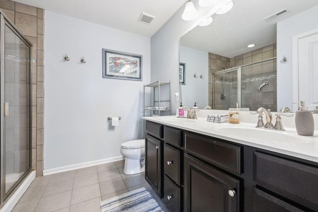 bathroom with a shower stall, tile patterned flooring, toilet, double vanity, and baseboards