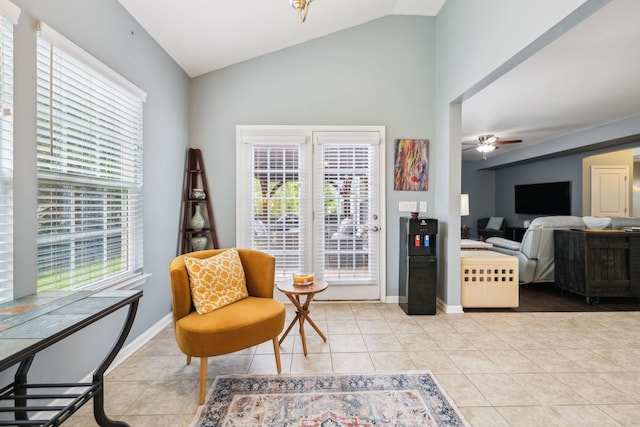sitting room with light tile patterned floors, vaulted ceiling, a ceiling fan, and baseboards