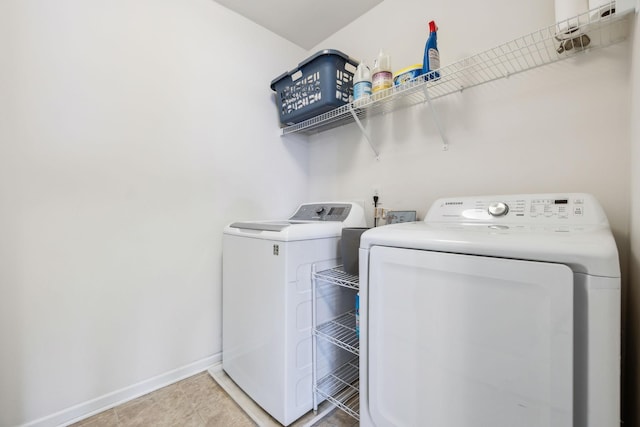 washroom with washer and dryer, baseboards, and light tile patterned floors