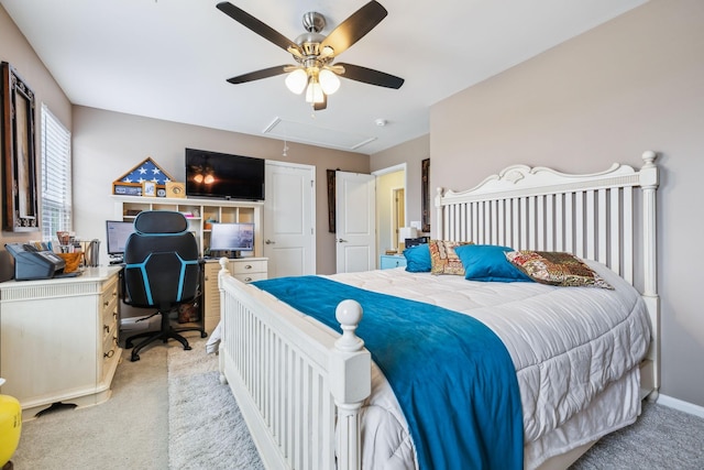 bedroom featuring attic access, light colored carpet, a desk, and ceiling fan