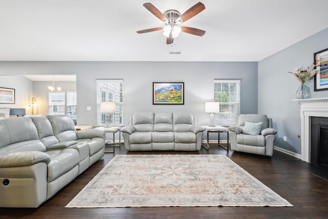 living room featuring healthy amount of natural light, a fireplace, a chandelier, and ceiling fan