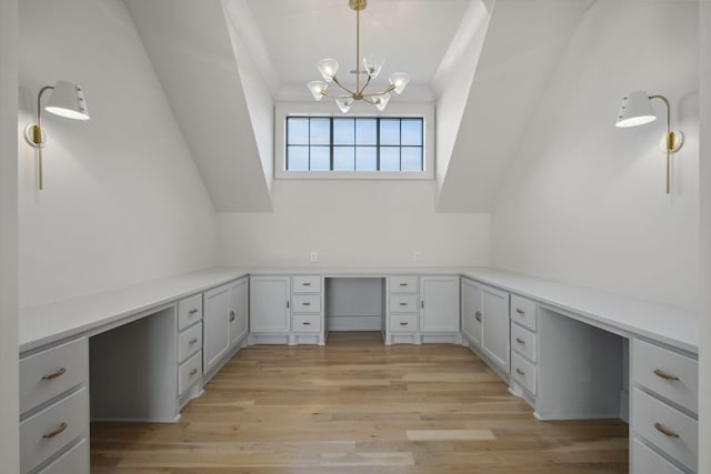 unfurnished office featuring built in study area, light wood-style flooring, and a chandelier