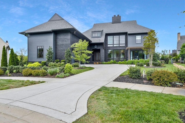 view of front of property featuring a chimney and a shingled roof