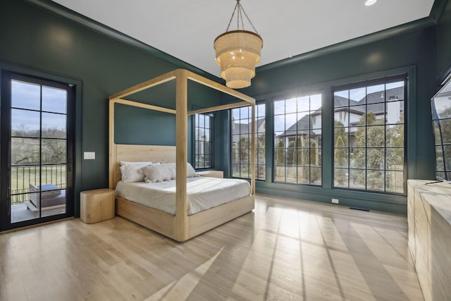 bedroom featuring wood finished floors, access to outside, a chandelier, and recessed lighting