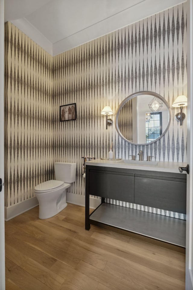 bathroom featuring toilet, wood finished floors, vanity, and baseboards