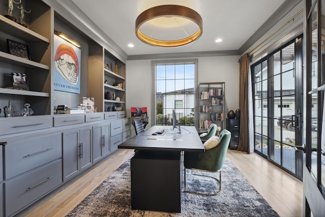 home office featuring light wood-style floors, built in features, a raised ceiling, and recessed lighting
