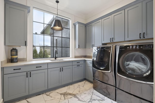 laundry area with cabinet space, washing machine and clothes dryer, and light marble finish floors