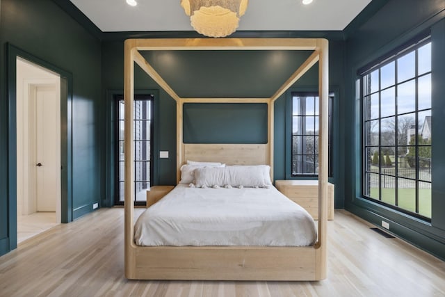 bedroom with multiple windows, wood finished floors, recessed lighting, and baseboards