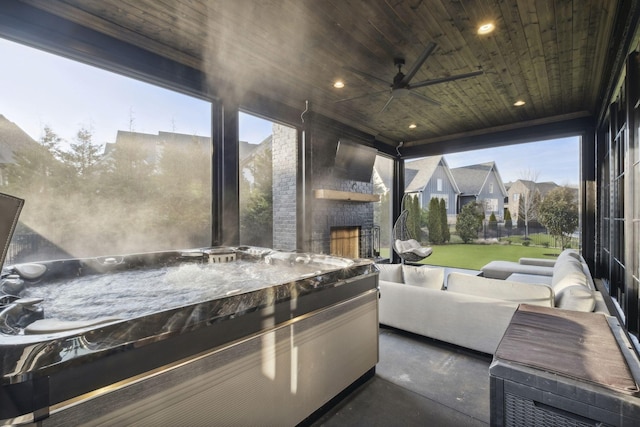 view of patio / terrace featuring ceiling fan and an outdoor living space with a fireplace