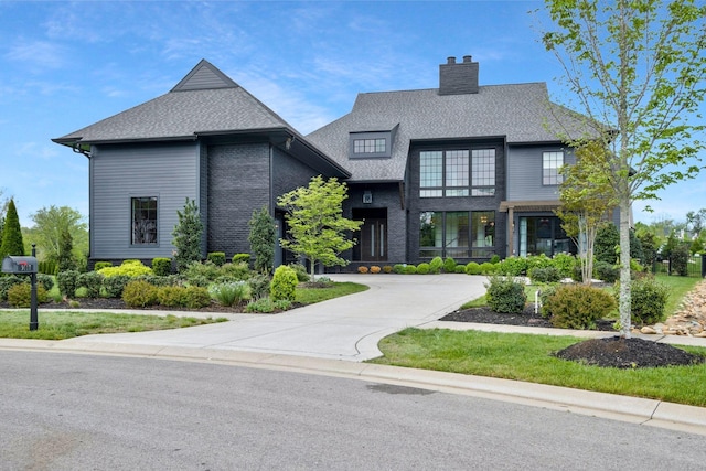 view of front of house featuring a chimney and a shingled roof