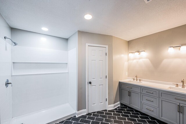 204 Wilson Ave, Auburn, KY 42206 - full bath featuring a shower, a textured ceiling, tile patterned floors, baseboards, and double vanity