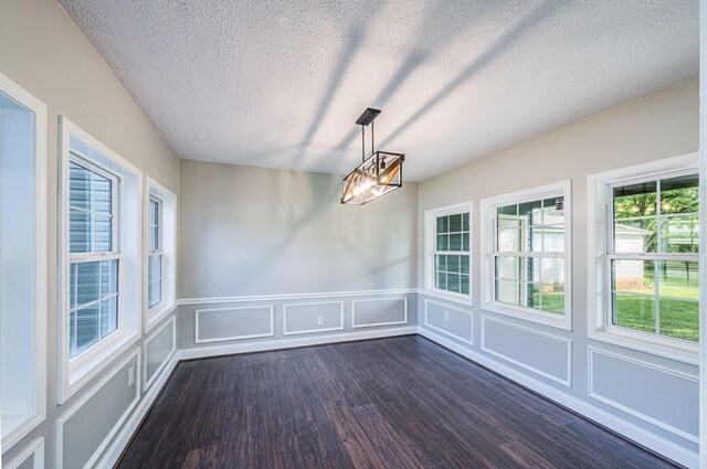 204 Wilson Ave, Auburn, KY 42206 - unfurnished dining area featuring a decorative wall, dark wood finished floors, a textured ceiling, and a wainscoted wall
