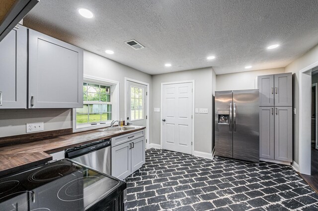 204 Wilson Ave, Auburn, KY 42206 - kitchen with stainless steel appliances, wood counters, a sink, recessed lighting, and brick floors