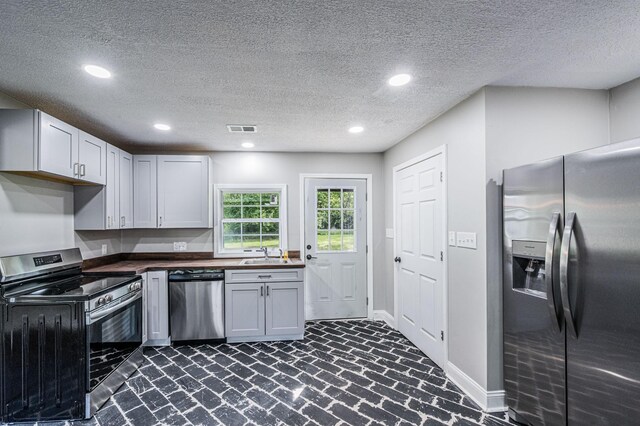 204 Wilson Ave, Auburn, KY 42206 - kitchen with stainless steel appliances, brick floors, a sink, recessed lighting, and baseboards