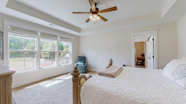548 Buddy Rd, Burns, TN 37029 - bedroom featuring a tray ceiling, wood finished floors, baseboards, and ceiling fan