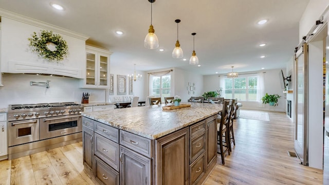 548 Buddy Rd, Burns, TN 37029 - kitchen featuring range with two ovens, a barn door, a breakfast bar area, light wood-style floors, and recessed lighting