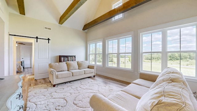548 Buddy Rd, Burns, TN 37029 - living room featuring high vaulted ceiling, healthy amount of natural light, beamed ceiling, light wood-style floors, and a barn door