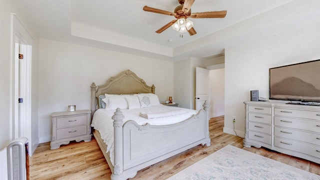548 Buddy Rd, Burns, TN 37029 - bedroom featuring a tray ceiling, light wood-style floors, ceiling fan, and baseboards