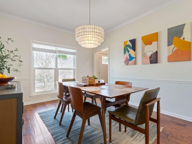 dining space featuring crown molding, dark wood-type flooring, a chandelier, and baseboards