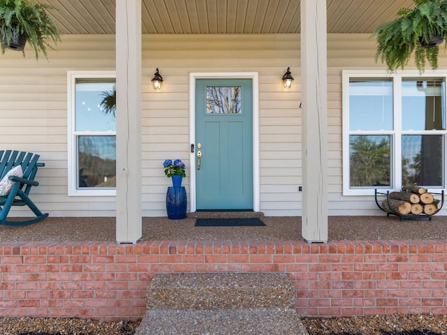 view of exterior entry featuring covered porch
