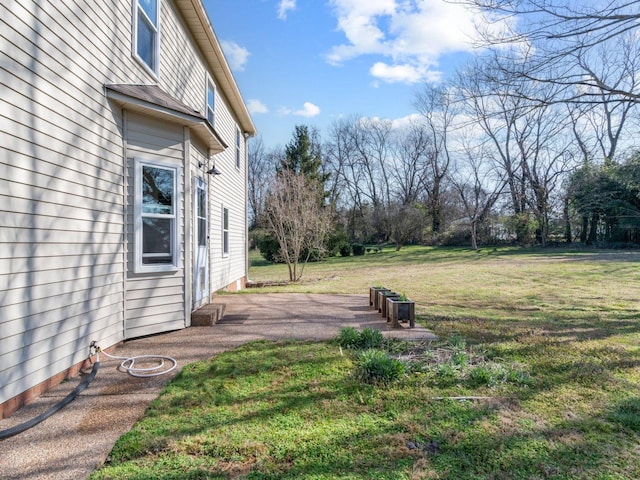 view of green lawn featuring a patio area
