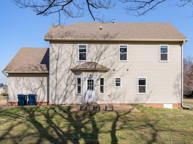 rear view of house featuring a lawn and roof with shingles
