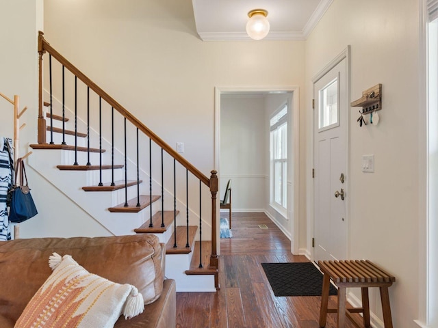 foyer with wood finished floors, ornamental molding, stairs, and baseboards