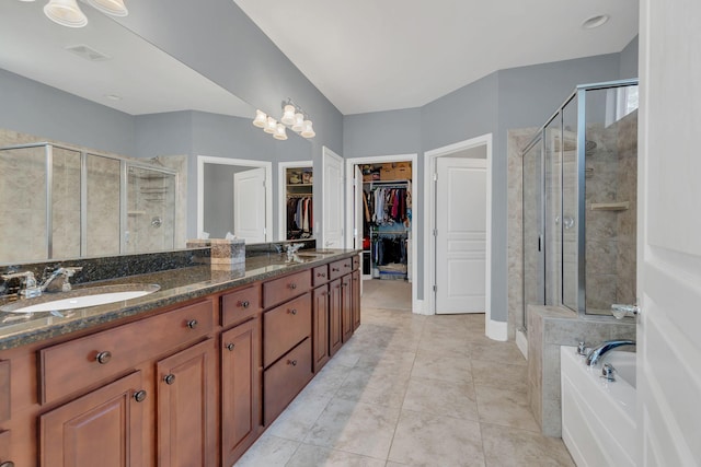 bathroom with a stall shower, a walk in closet, a bath, and double vanity