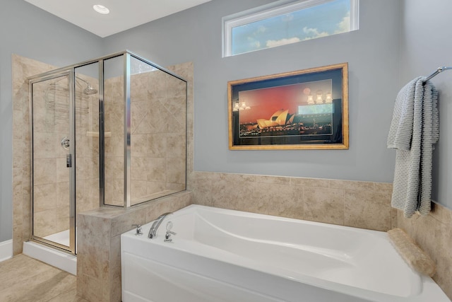 bathroom with a stall shower and a bath