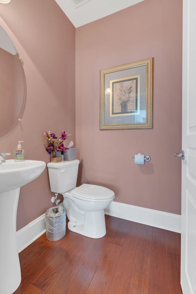 bathroom featuring wood finished floors, toilet, and baseboards