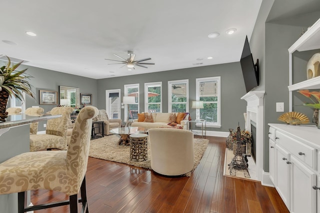 living room featuring ceiling fan, a fireplace, dark wood finished floors, and recessed lighting