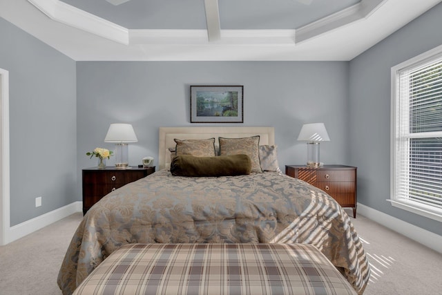 carpeted bedroom with crown molding, baseboards, and a tray ceiling