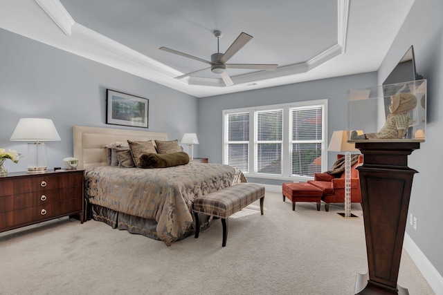 bedroom featuring a raised ceiling, light carpet, ceiling fan, and baseboards