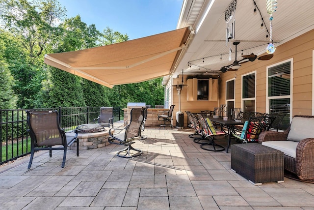 view of patio with a fire pit, outdoor dining space, and ceiling fan
