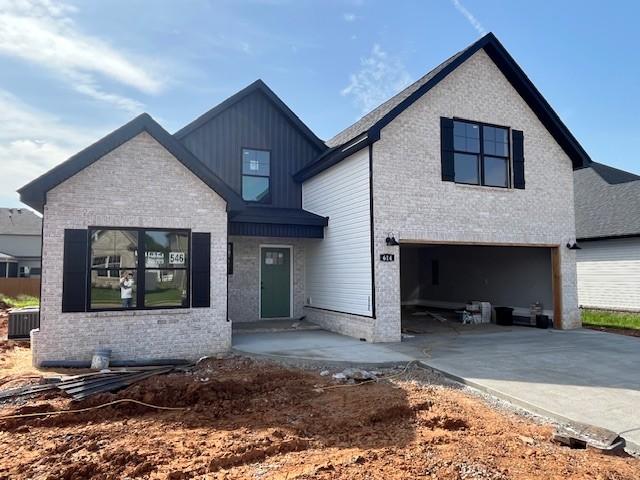 614 Woodrush Dr, Clarksville, TN 37040 - modern farmhouse with an attached garage, driveway, brick siding, and board and batten siding