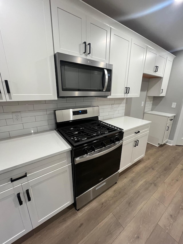 614 Woodrush Dr, Clarksville, TN 37040 - kitchen featuring stainless steel appliances, wood finished floors, backsplash, white cabinetry, and light countertops
