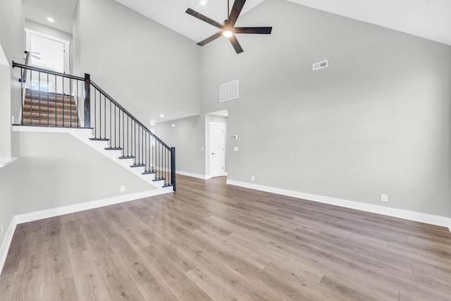 614 Woodrush Dr, Clarksville, TN 37040 - unfurnished living room featuring ceiling fan, high vaulted ceiling, wood finished floors, and stairway