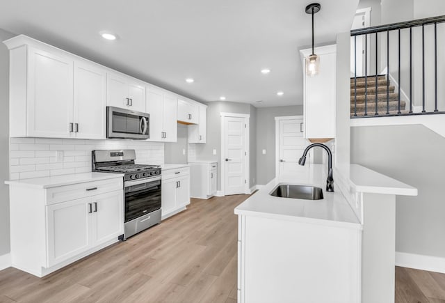 614 Woodrush Dr, Clarksville, TN 37040 - kitchen featuring appliances with stainless steel finishes, recessed lighting, light wood finished floors, decorative backsplash, and light countertops