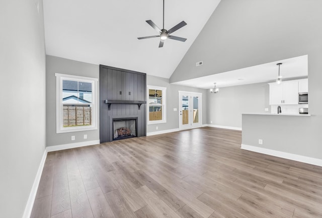 614 Woodrush Dr, Clarksville, TN 37040 - unfurnished living room featuring high vaulted ceiling, ceiling fan, a large fireplace, wood finished floors, and a chandelier