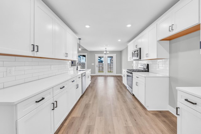 614 Woodrush Dr, Clarksville, TN 37040 - kitchen with appliances with stainless steel finishes, white cabinetry, light countertops, light wood-type flooring, and recessed lighting