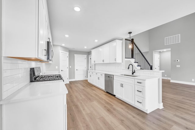 614 Woodrush Dr, Clarksville, TN 37040 - kitchen featuring stainless steel appliances, a peninsula, tasteful backsplash, white cabinets, and light countertops