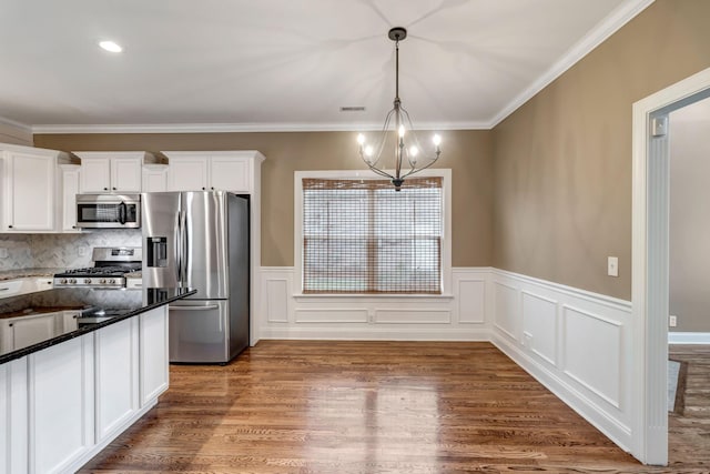 1317 Sam Houston Ave, Murfreesboro, TN 37129 - kitchen with appliances with stainless steel finishes, a chandelier, white cabinets, decorative light fixtures, and wood finished floors