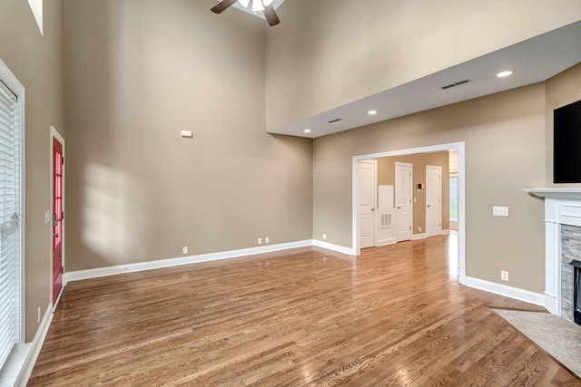 1317 Sam Houston Ave, Murfreesboro, TN 37129 - unfurnished living room with ceiling fan, a fireplace with flush hearth, light wood-style floors, a towering ceiling, and baseboards