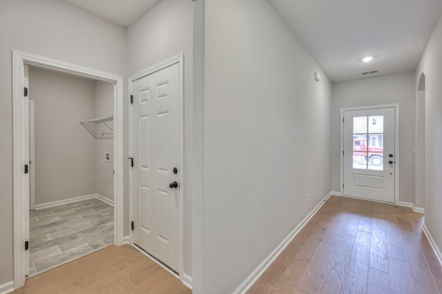 doorway featuring light wood-style flooring and baseboards