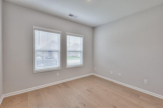 spare room with light wood-style floors and baseboards