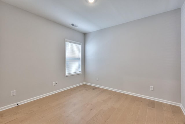 spare room with baseboards and light wood-style flooring