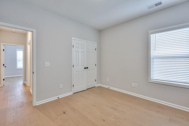 spare room with light wood-type flooring and baseboards