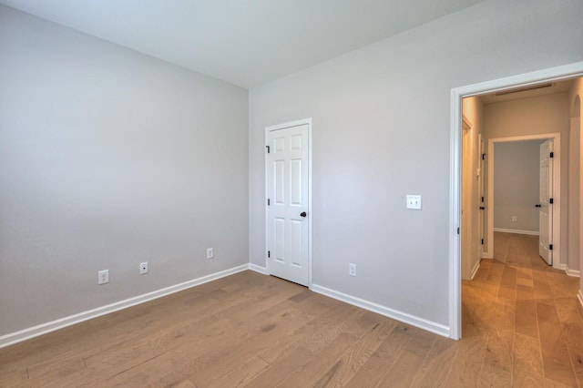 unfurnished bedroom featuring light wood-style flooring and baseboards
